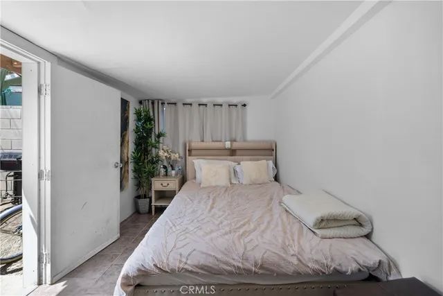 a bedroom with a bed and a potted plant