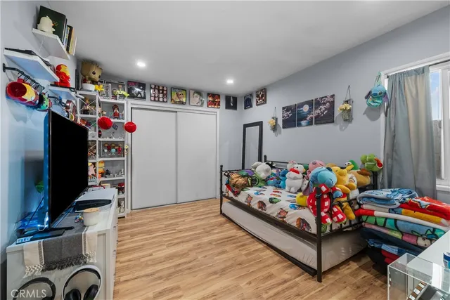 a living room with baby crib furniture and a flat screen tv