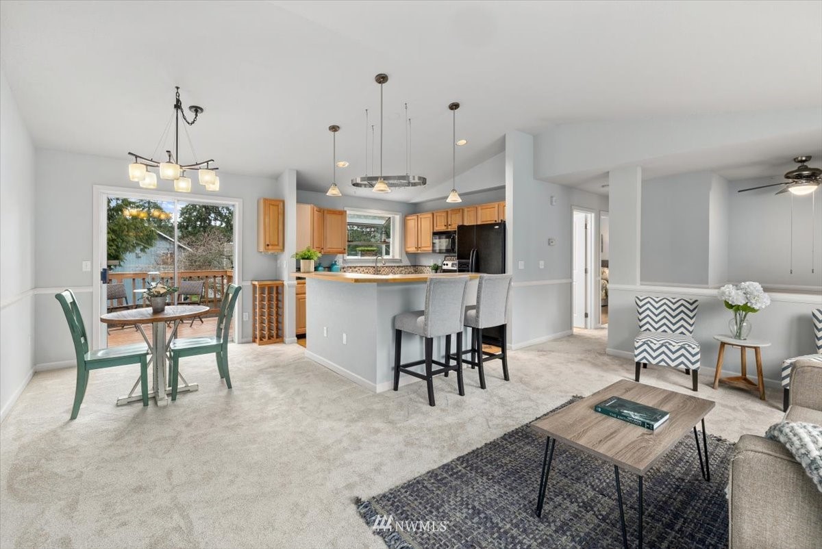 1723 225th Street Southeast Bothell, WA 98021 - Photo 5 of 40 a living room with kitchen island furniture and a chandelier