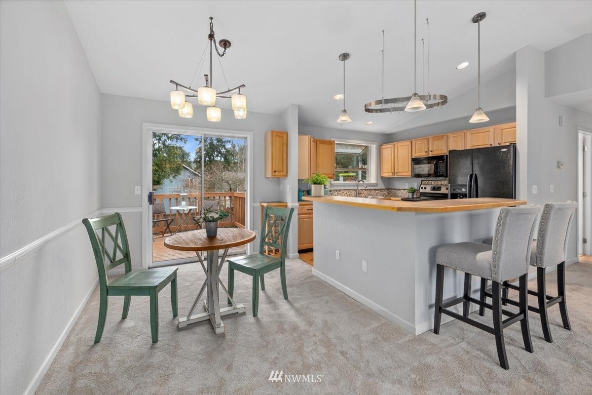 1723 225th Street Southeast Bothell, WA 98021 - Photo 7 of 40 a kitchen with a dining table chairs sink and cabinets