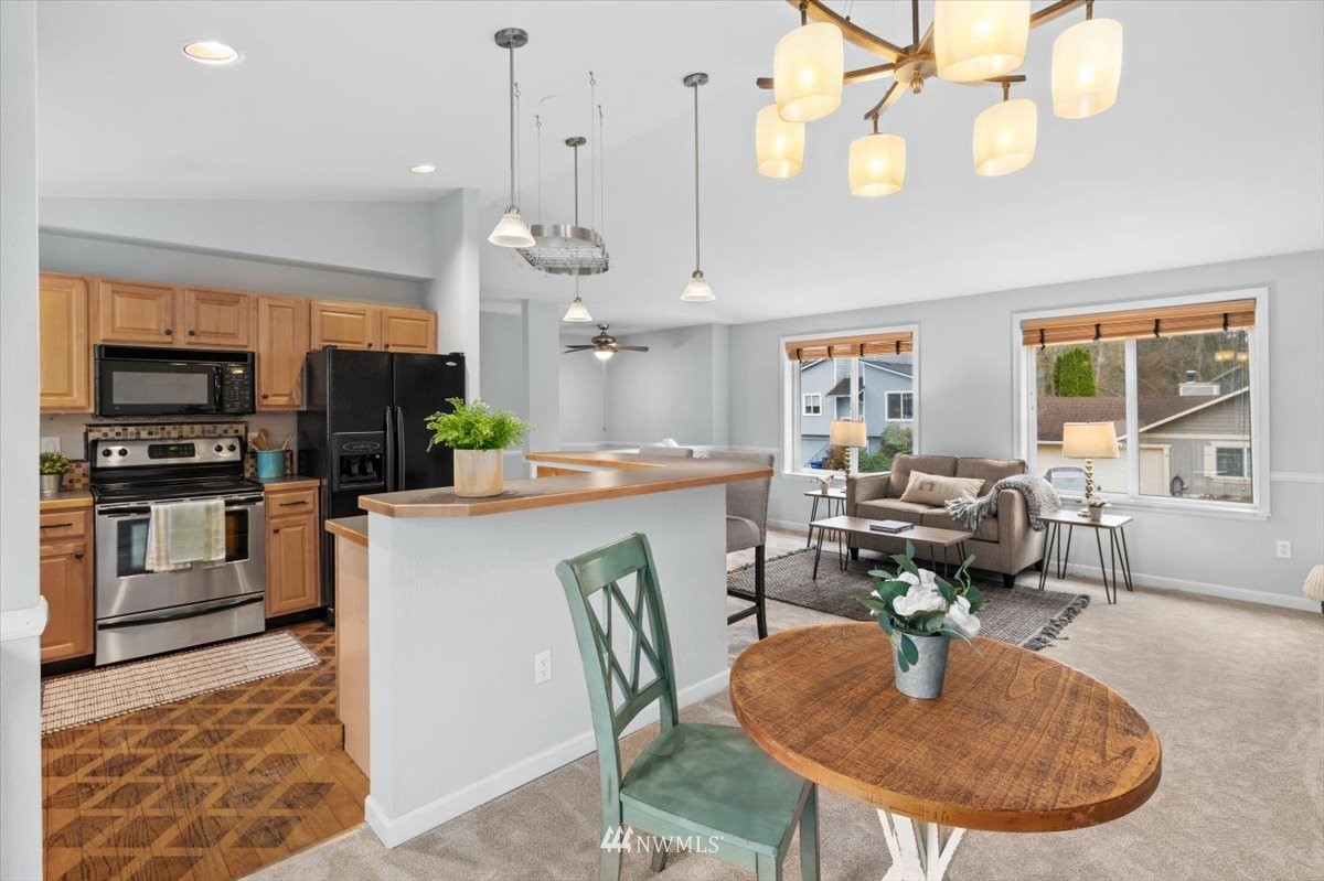 1723 225th Street Southeast Bothell, WA 98021 - Photo 9 of 40 a open kitchen with dining table and stainless steel appliances
