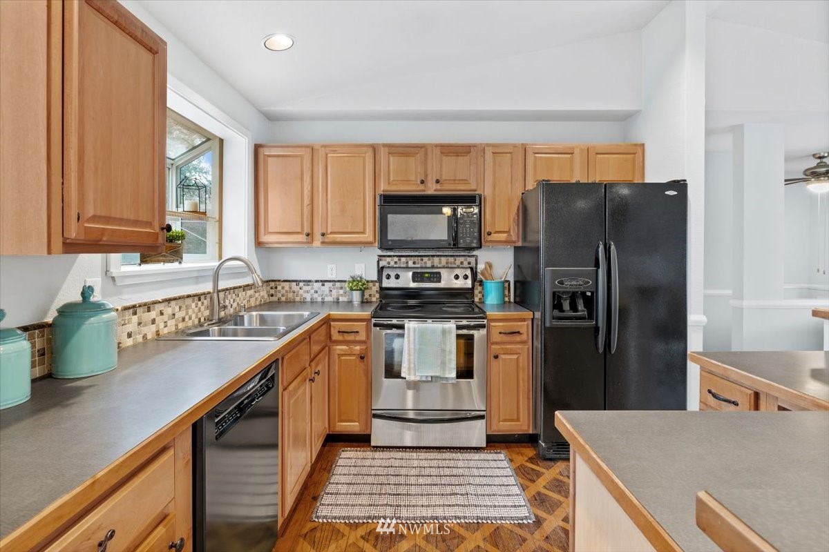 1723 225th Street Southeast Bothell, WA 98021 - Photo 10 of 40 a kitchen with a refrigerator a sink and a stove