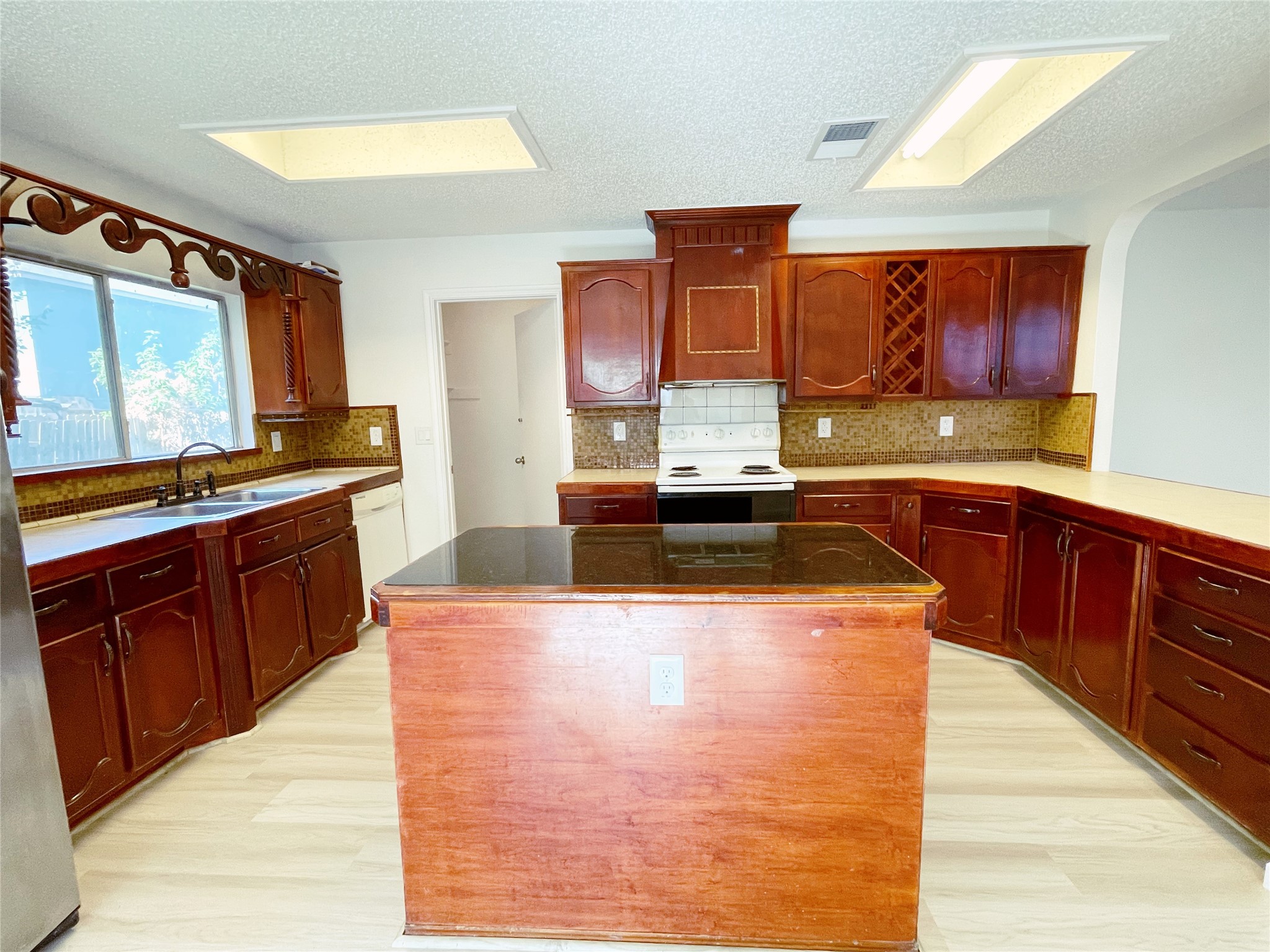 1103 Pike Path Round Rock, TX 78665 - Photo 13 of 36 The rich tones of the cabinets add a touch of elegance and warmth to the space, while the spacious countertops offer plenty of room for meal preparation and entertaining. Combined with natural light streaming in, this kitchen becomes a welcoming hub for culinary creativity and social gatherings alike.