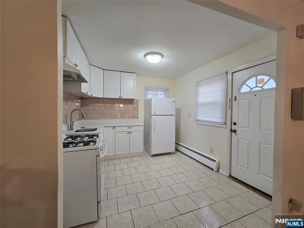 a kitchen with granite countertop a refrigerator and a stove top oven