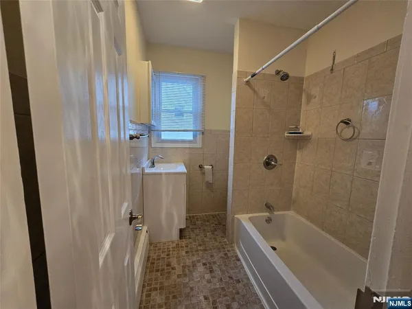 a bathroom with a tub a sink and a shower