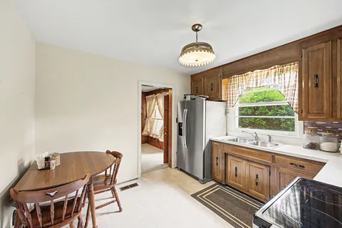 a kitchen with a table chairs and a refrigerator