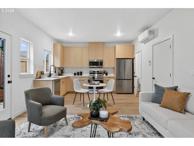 a living room with stainless steel appliances kitchen island granite countertop a couch and a view of kitchen