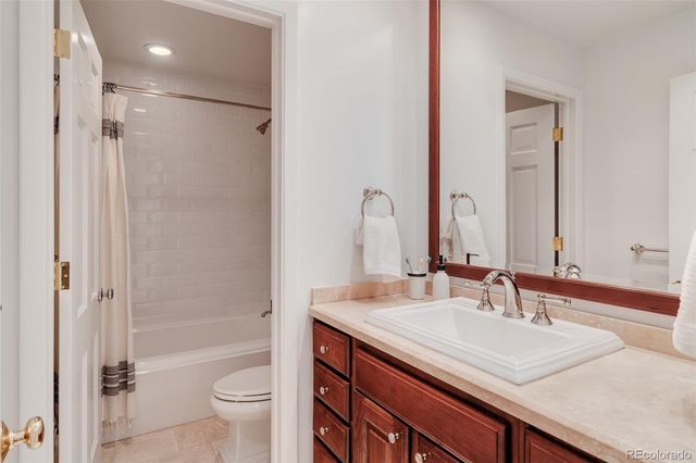 a bathroom with a granite countertop sink a toilet and shower
