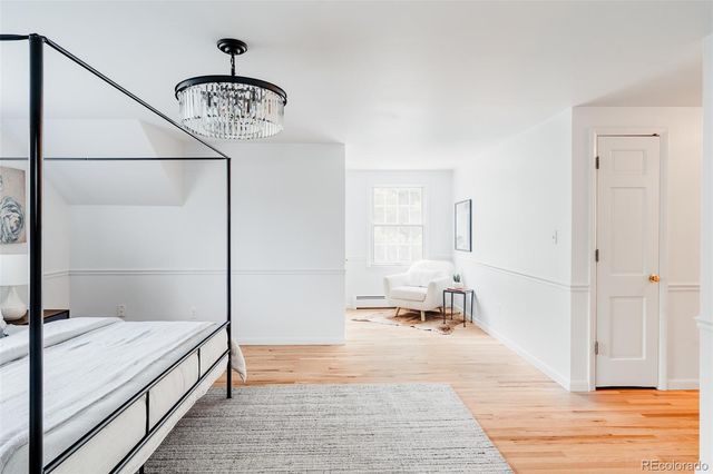 a bedroom with a bed and a chandelier