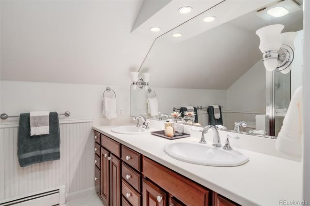 a bathroom with double vanity sinks and a mirror