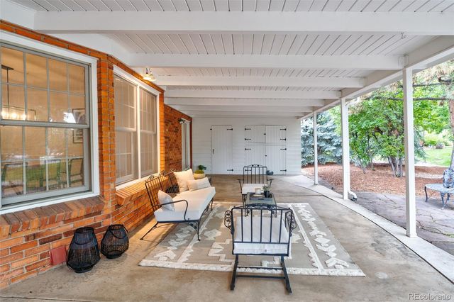 a living room with furniture a table and a floor to ceiling window