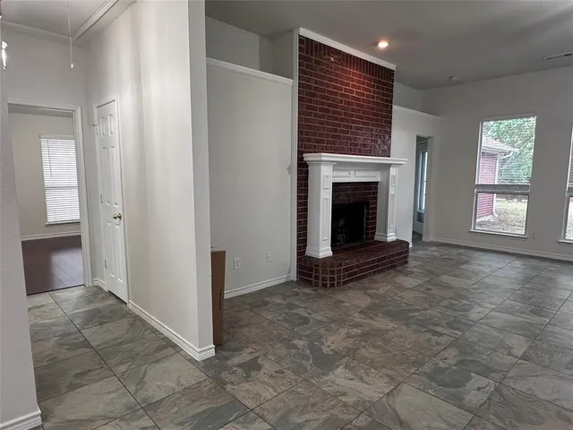 an empty room with windows and fireplace