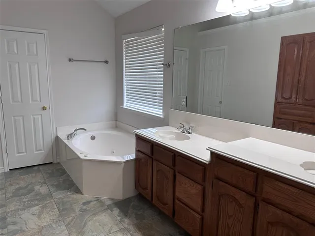a bathroom with a tub sink and mirror
