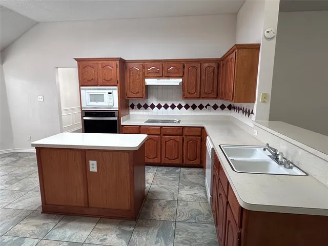 a kitchen with a stove a sink and a refrigerator