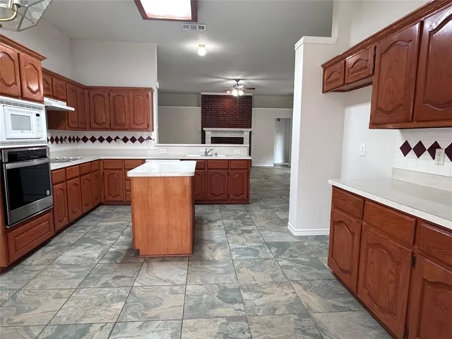 a large kitchen with stainless steel appliances granite countertop a sink and cabinets