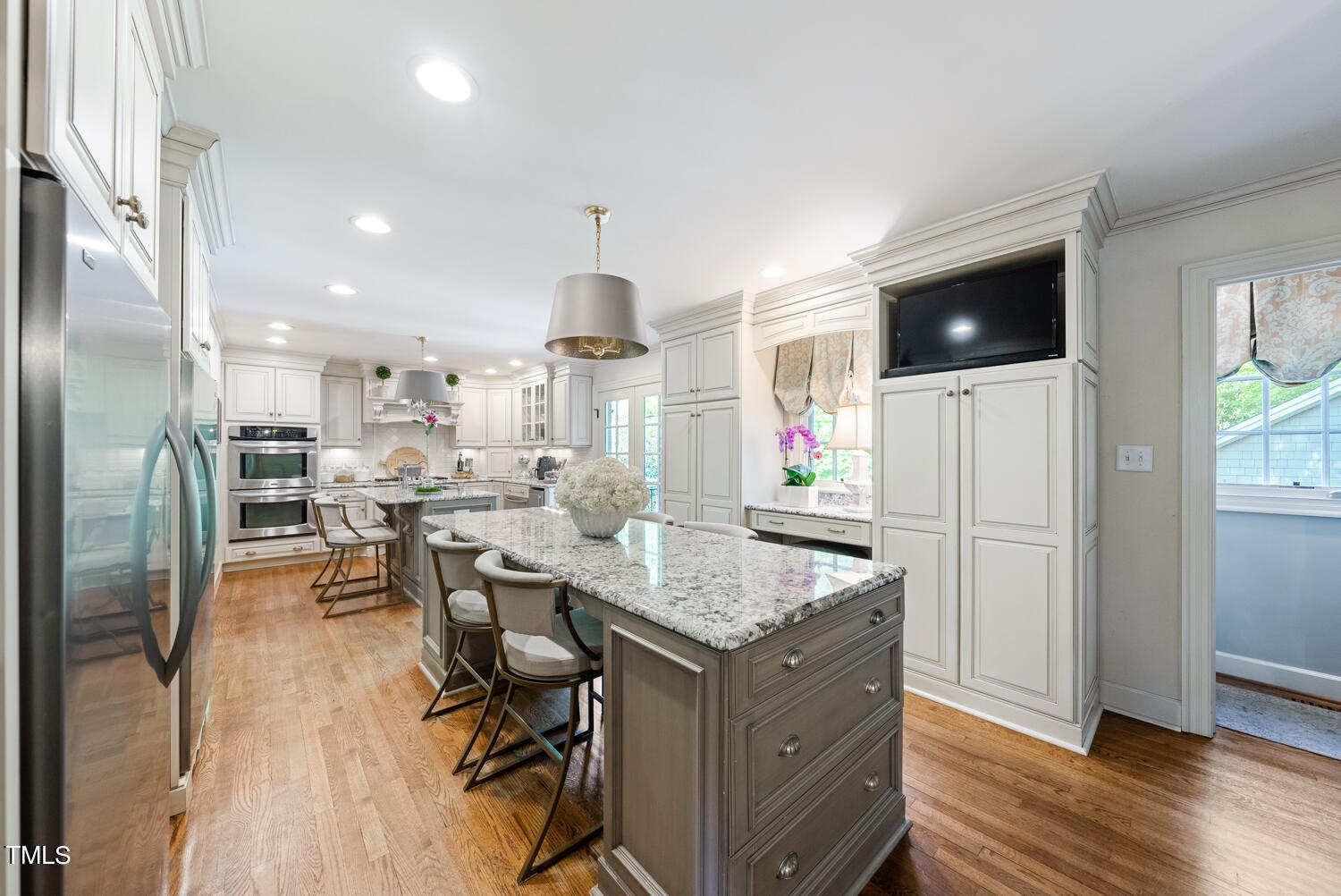 2421 Tyson Street Raleigh, NC 27612 - Photo 19 of 61 a kitchen with stainless steel appliances kitchen island granite countertop a refrigerator a stove a microwave oven a sink with island and chairs