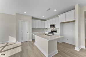 2760 River Meadow Spring Hope, NC 27882 - Photo 13 of 42 a kitchen with a sink a stove a refrigerator and white cabinets