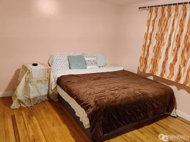 a bedroom with a bed and wooden floor