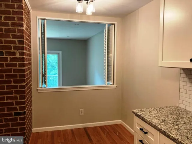 a view of a livingroom with wooden floor and a fireplace