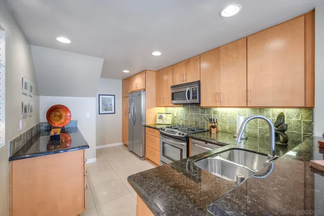 a kitchen with stainless steel appliances granite countertop a refrigerator and a stove top oven