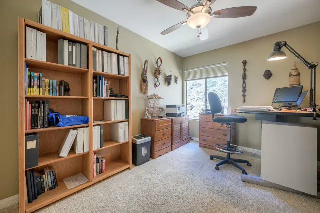 a view of a workspace with furniture and a bookshelf