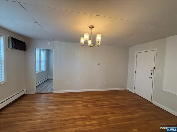 a view of wooden floor chandelier and closet in an empty room