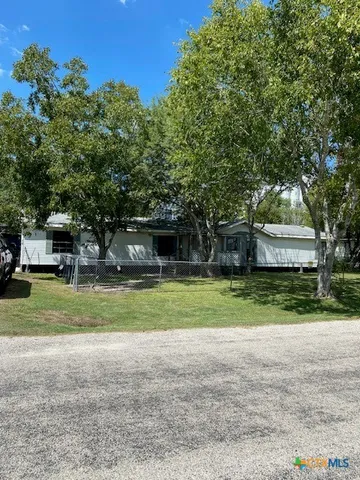 a front view of a house with a yard and trees