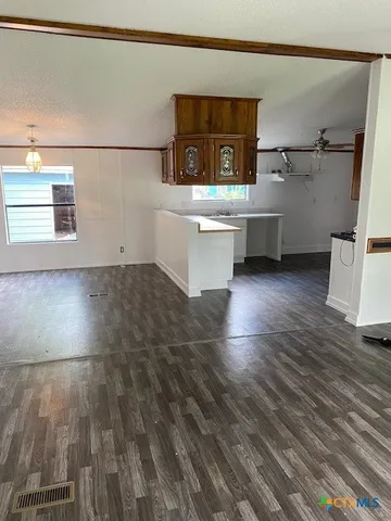a view of a kitchen with wooden floor and electronic appliances