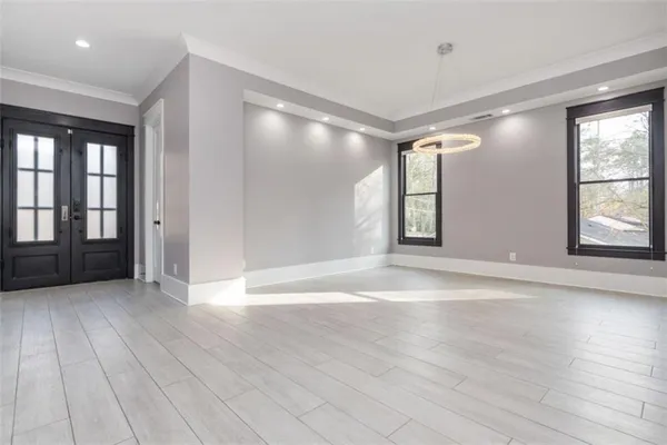 a view of an empty room with kitchen and a window