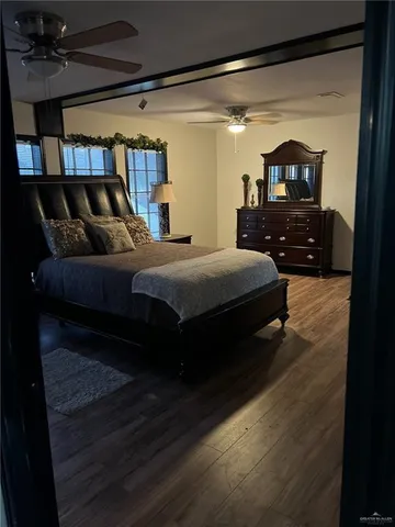 a bedroom with a bed a mirror and a flat tv screen on a dresser