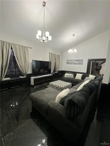 a spacious bedroom with a bed and a chandelier