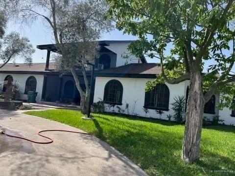 a view of a house with backyard and tree