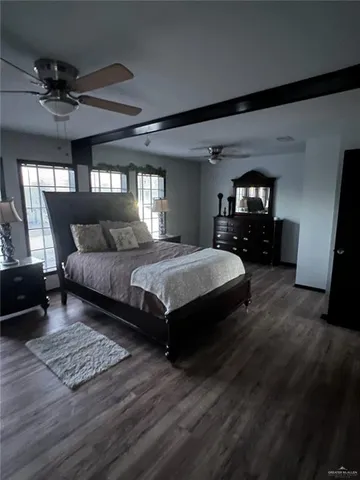 a bedroom with a large bed a chandelier and dresser