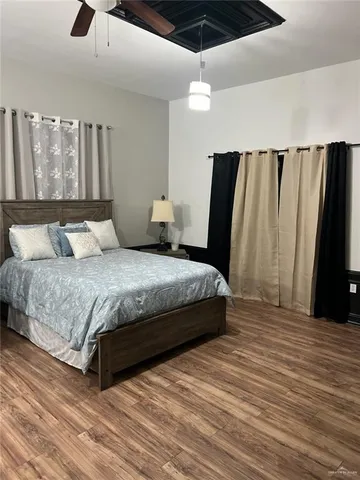a bedroom with a large bed and a chandelier