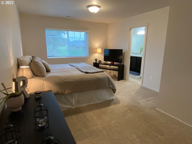 2018 South Taverner Drive Ridgefield, WA 98642 - Photo 17 of 32 a bedroom with a bed and a flat screen tv