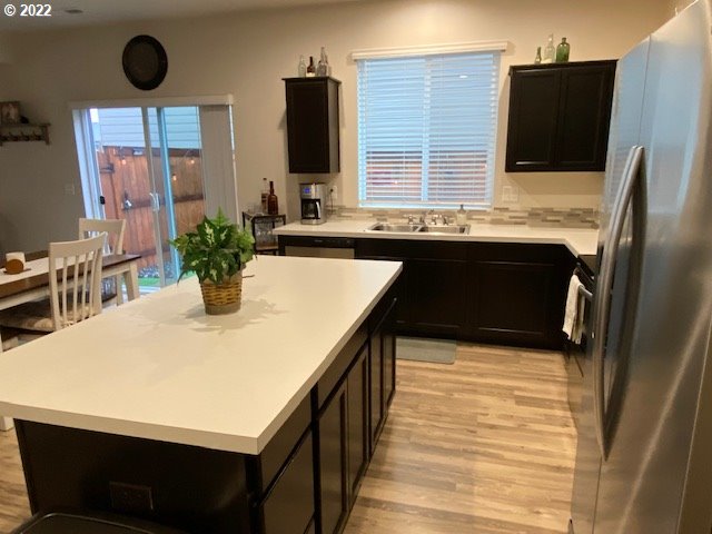 2018 South Taverner Drive Ridgefield, WA 98642 - Photo 10 of 32 a kitchen with stainless steel appliances kitchen island a table chairs in it and wooden floors