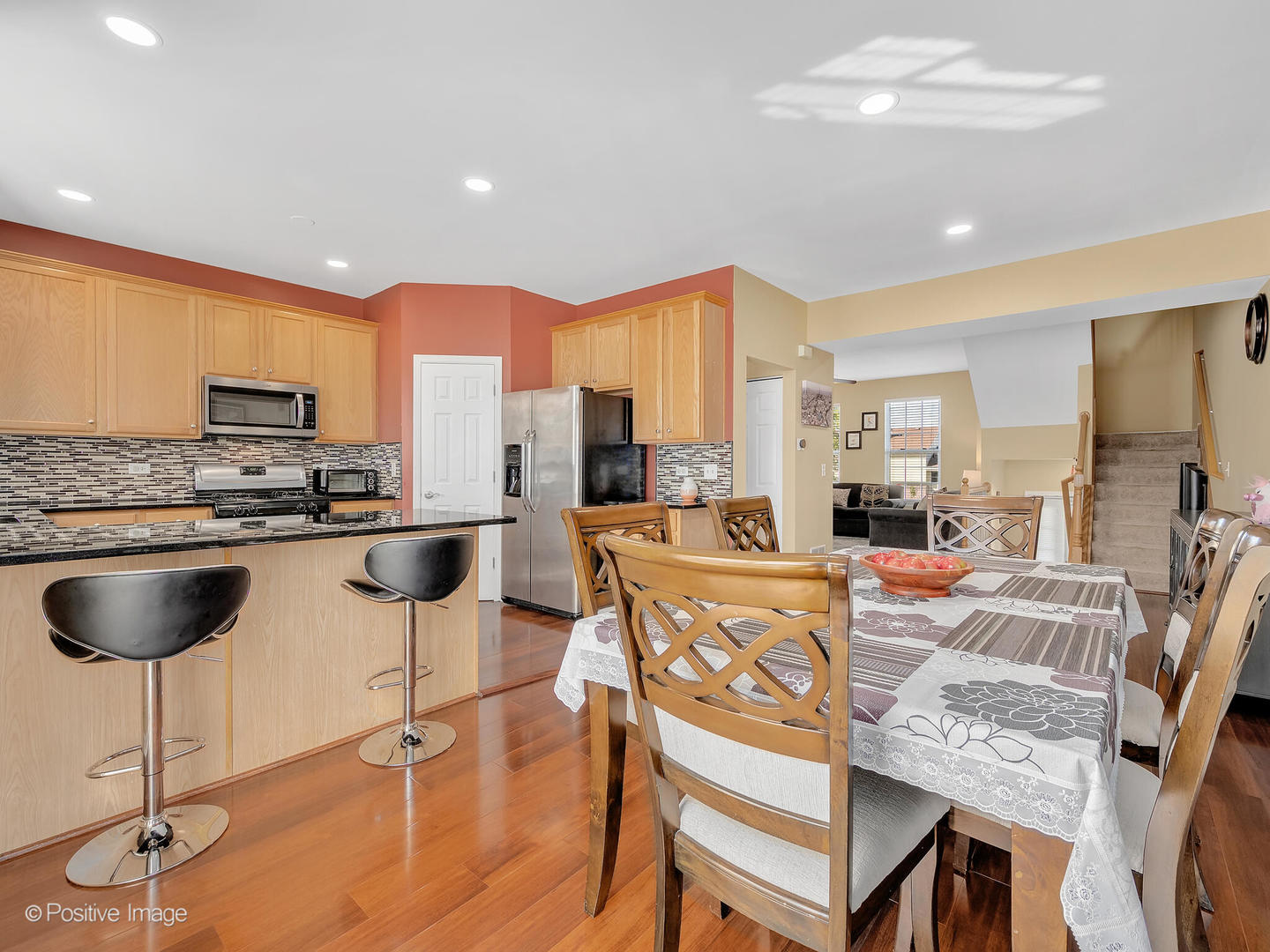 6567 Church Street Hanover Park, IL 60133 - Photo 7 of 19 a kitchen with stainless steel appliances granite countertop a stove top oven a sink a dining table and chairs