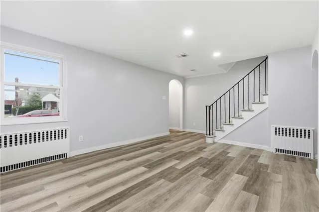 a view of a hallway with wooden floor and windows