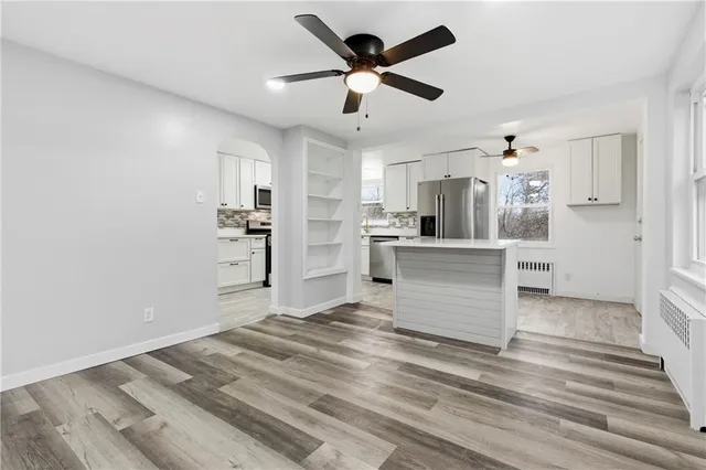 a view of a kitchen with wooden floor and a ceiling fan