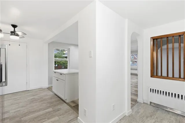 a view of a kitchen with white cabinets and window