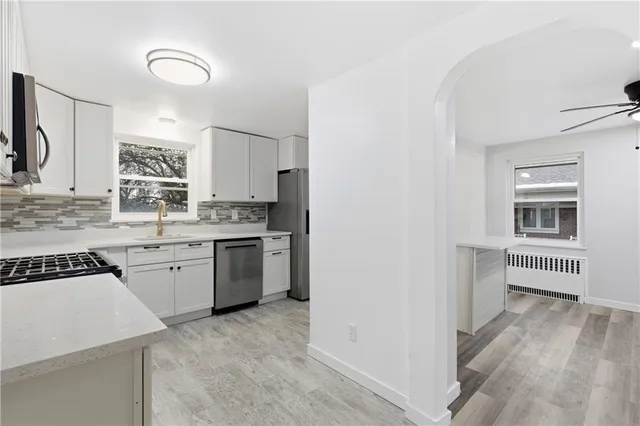 a kitchen with granite countertop white cabinets and white appliances