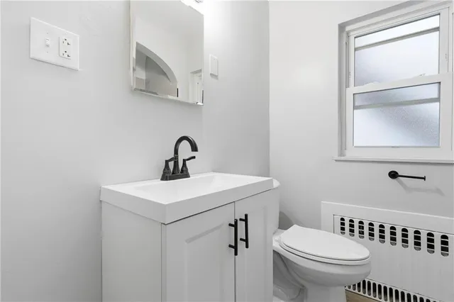 a bathroom with a sink a toilet and window