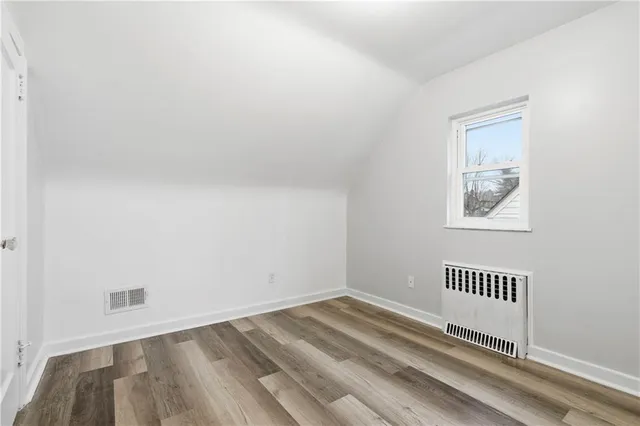 a view of a hallway with wooden floor and a window
