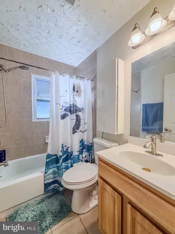 a bathroom with a sink a toilet a mirror a bathtub and shower