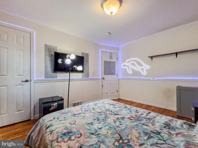 a bedroom with a bed and a flat tv screen on wall