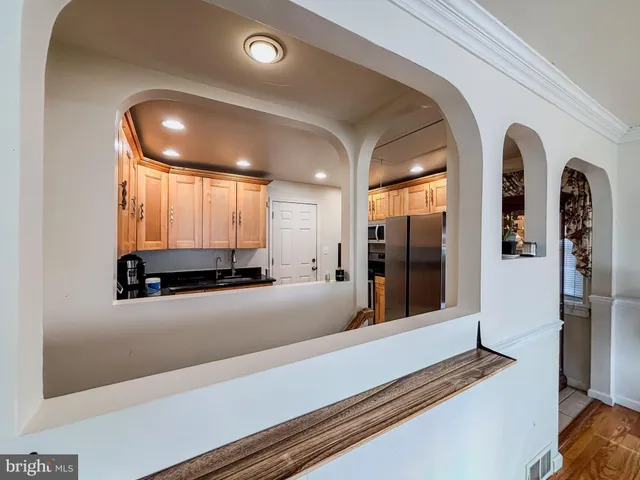 a view of a hallway with wooden floor and chandelier