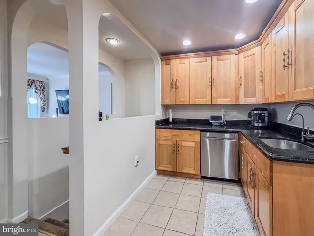 a kitchen with granite countertop a sink stove and cabinets