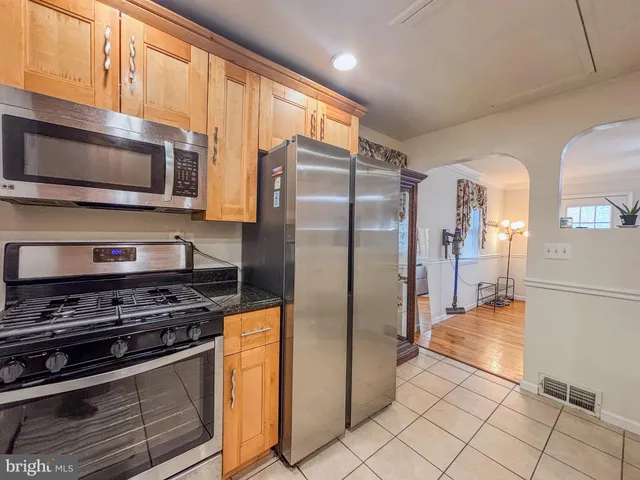a kitchen with stainless steel appliances granite countertop a refrigerator and a stove top oven