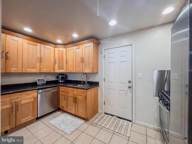 a kitchen with stainless steel appliances granite countertop a refrigerator and a sink