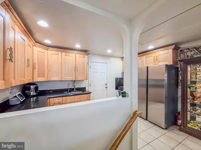 a large kitchen with stainless steel appliances a refrigerator and a sink